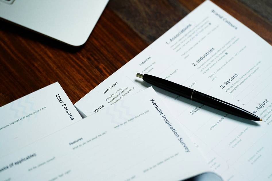 Backpacker reviewing motorcycle insurance documents beside a parked adventure bike